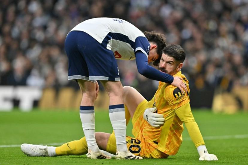 Tottenham Hotspur's English midfielder #14 Archie Gray (L) checks on Tottenham Hotspur's English goalkeeper #20 Fraser Forster (R) during the English Premier League football match between Tottenham Hotspur and Wolverhampton Wanderers at the Tottenham Hotspur Stadium in London, on December 29, 2024.  Glyn KIRK / AFP