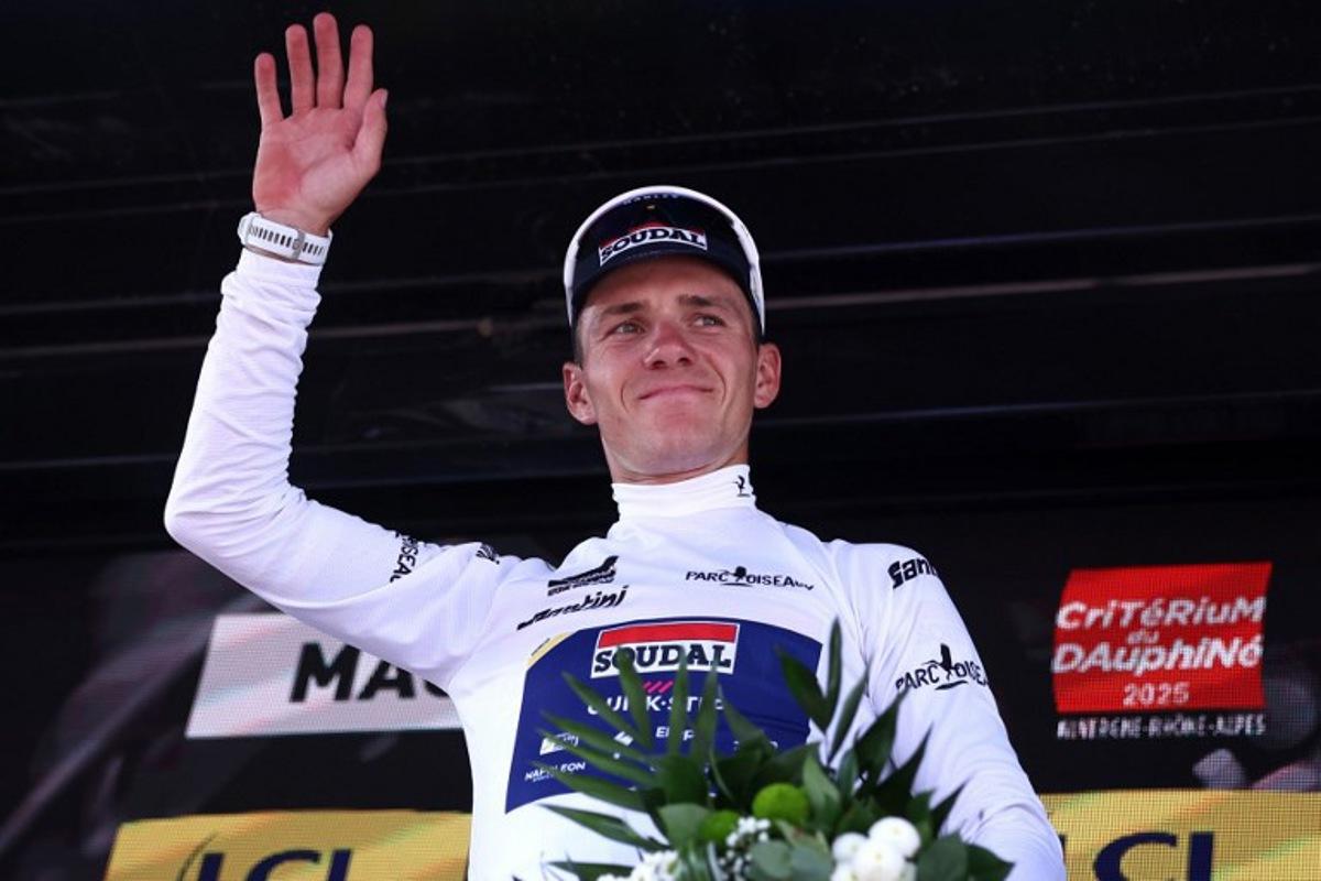 Soudal Quick-Step's Belgian rider Remco Evenepoel wearing the best young rider's white jersey celebrates on the podium of the 5th stage of the 77th edition of the Criterium du Dauphine cycling race, 183 km between Saint-Priest and Mâcon, on June 12, 2025.  Anne-Christine POUJOULAT / AFP