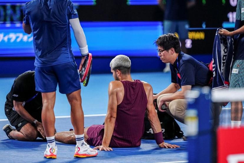 Spain's Carlos Alcaraz gets medical attention during his men's singles round-of-32 match against Argentina's Sebastian Baez at the ATP Japan Open tennis tournament in Tokyo on September 25, 2025.  Yuichi YAMAZAKI / AFP