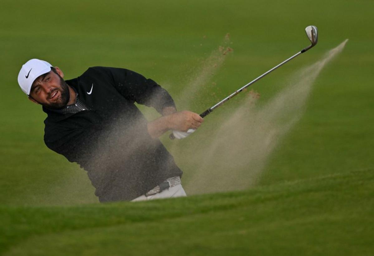US golfer Scottie Scheffler plays from a bunker on the 12th hole on day three of the 153rd Open Championship at Royal Portrush golf club in Northern Ireland on July 19, 2025.  Glyn KIRK / AFP