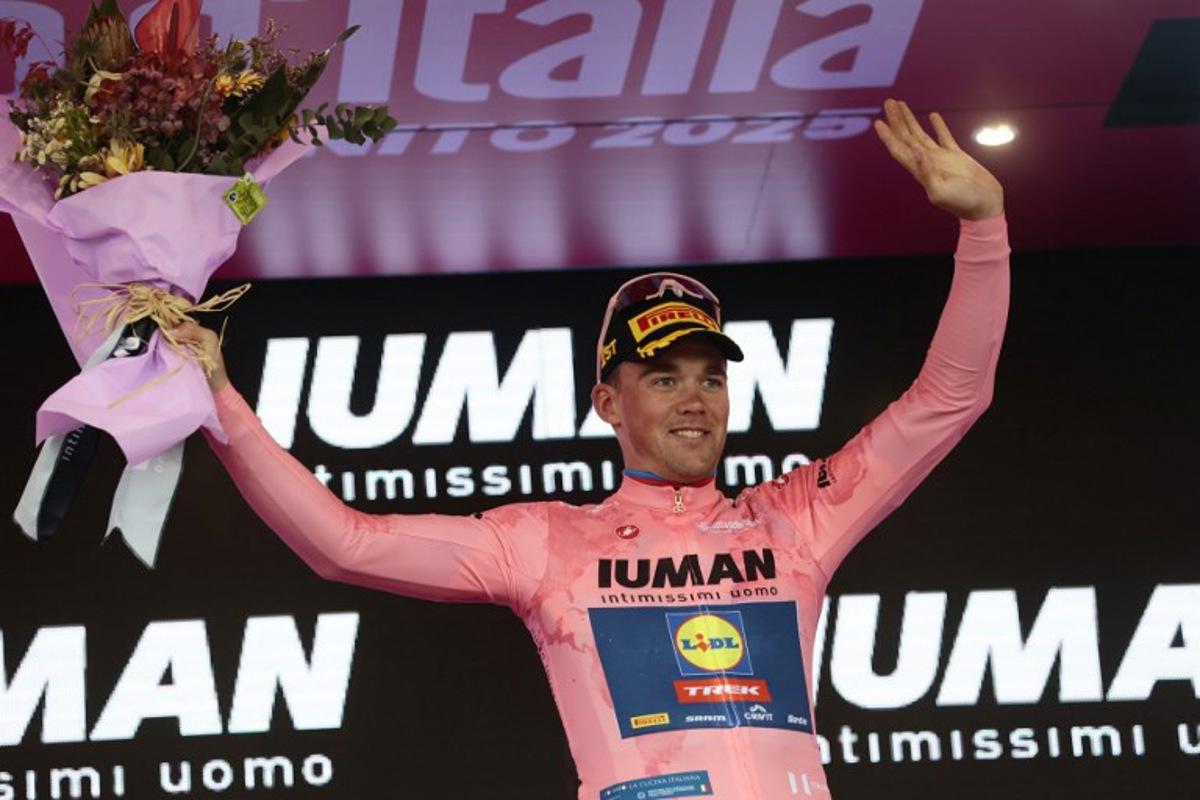 Overall leader Lidl-Trek's Danish rider Mads Pedersen celebrates on the podium of the 6th stage of the 108th Giro d'Italia cycling race 227kms from Potenza to Naples on May 15, 2025.  Luca Bettini / AFP