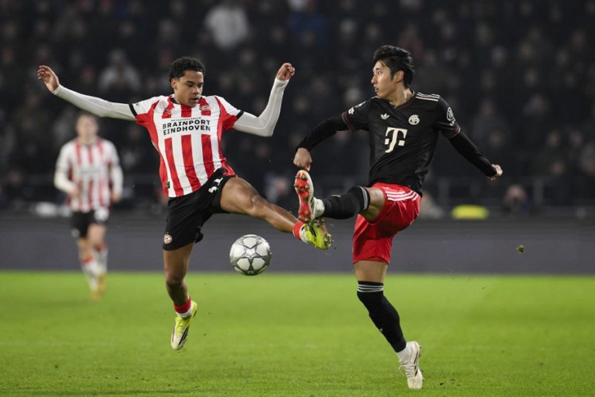 PSV Eindhoven's Belgian midfielder #31 Noah Fernandez (L) fights for the ball with Bayern Munich's Japanese defender #21 Hiroki Ito during the UEFA Champions League league phase day 8 football match between PSV Eindhoven and Bayern Munich at Philips Stadion in Eindhoven on January 28, 2026.  JOHN THYS / AFP