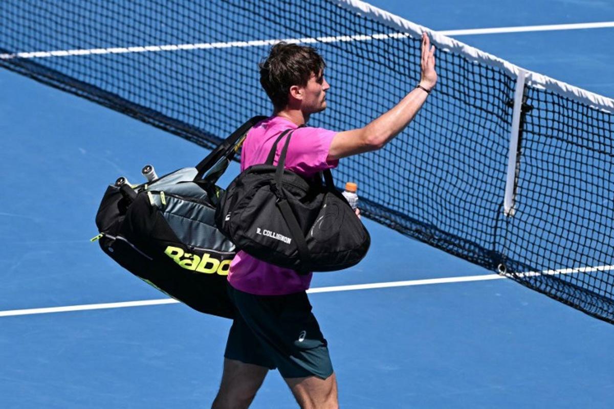 Belgium's Raphael Collignon acknowledges the crowd after he was forced to retire from the men's singles match against Italy's Lorenzo Musetti on day three of the Australian Open tennis tournament in Melbourne on January 20, 2026.  WILLIAM WEST / AFP
