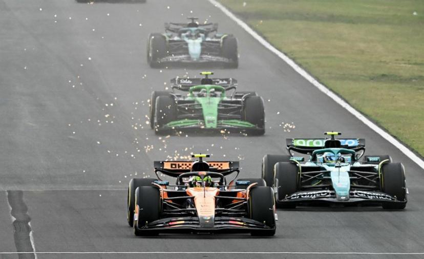 McLaren's British driver Lando Norris (L) and Aston Martin's Spanish driver Fernando Alonso (R) compete during the Formula One Hungarian Grand Prix at the Hungaroring circuit in Mogyorod near Budapest, Hungary, on August 3, 2025.  Attila KISBENEDEK / AFP