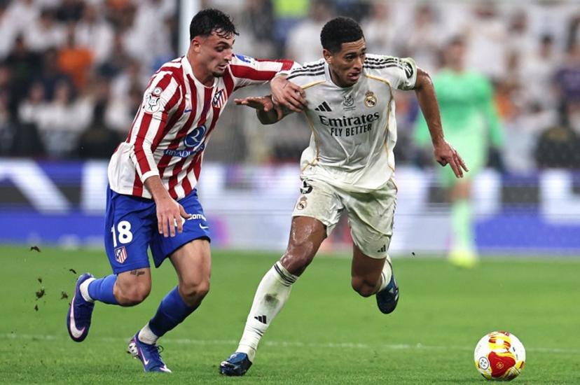 Real Madrid's Spanish defender #18 Alvaro Carreras fights for the ball with Real Madrid's English midfielder #05 Jude Bellingham during the Spanish Supercup semi-final football match between Atletico Madrid and Real Madrid at King Abdullah Sports City in Jeddah on January 8, 2026.  Fadel SENNA / AFP