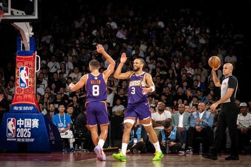 Phoenix Suns' Dillon Brooks (C) high-fives Grayson Allen (L) after scoring two points during the NBA pre-season basketball game between the Phoenix Suns and the Brooklyn Nets at the Venetian Arena in Macau on October 12, 2025. The NBA brought star-studded lineups to Macau this week for the league's return to China after six years, but many of the biggest wins happened off the basketball court, industry insiders and experts told AFP. Eduardo LEAL / AFP