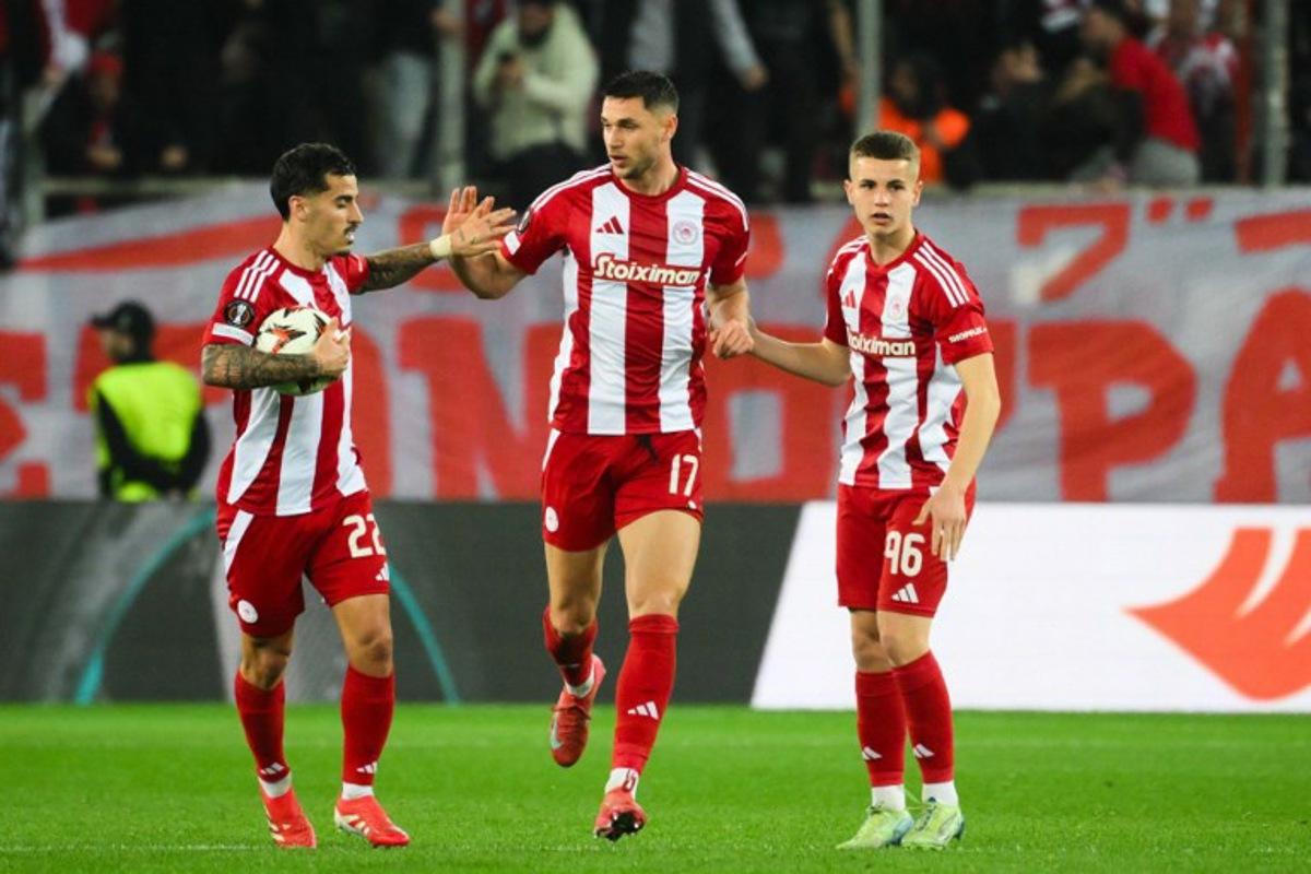 Olympiakos' Ukrainian forward #17 Roman Yaremchuk (C) celebrates with teammates Olympiakos' Portuguese mifielder #22 Chiquinho (L) and Olympiakos' Greek midfielder #96 Christos Mouzakitis (R) after scoring the 2-1 goal during the second leg last 16 UEFA Europa League football match between Olympiacos (GRE) and Bodo/Glimt (NOR) at Stadio Georgios Karaiskakis in Piraeus on March 13, 2025.   Angelos TZORTZINIS / AFP