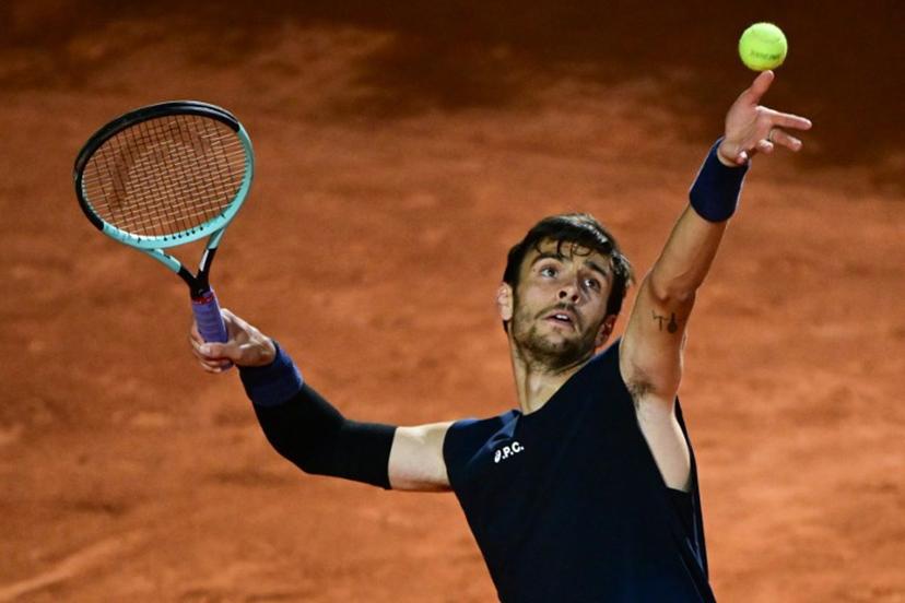 Italy's Lorenzo Musetti serves to Germany's Alexander Zverev during the men's singles quarter-final match at the ATP Rome Open tennis tournament at Foro Italico in Rome on May 14, 2025.  PIERO CRUCIATTI / AFP
