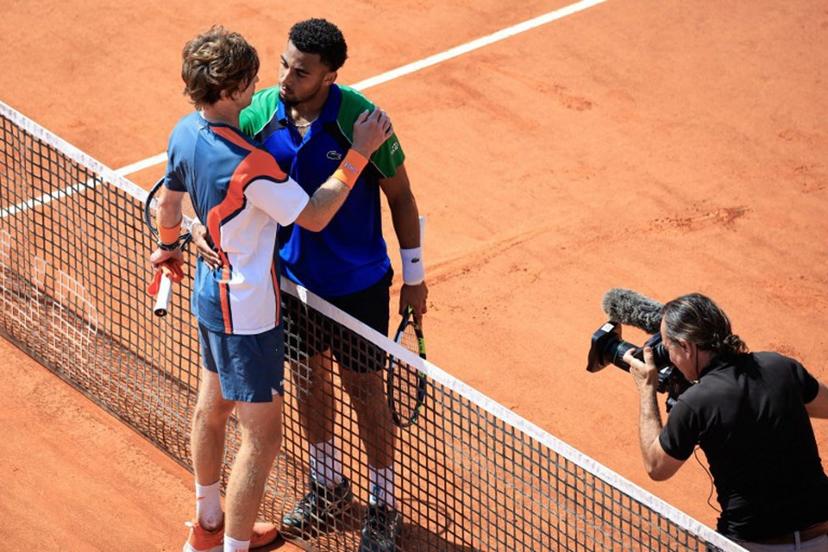 France's Arthur Fils (C) hugs Russia's Andrey Rublev (L) after winning during the Monte Carlo ATP Masters Series Tournament round of 16 tennis match on the Court des Princes at the Monte Carlo Country Club in Roquebrune-Cap-Martin on April 10, 2025.  Valery HACHE / AFP