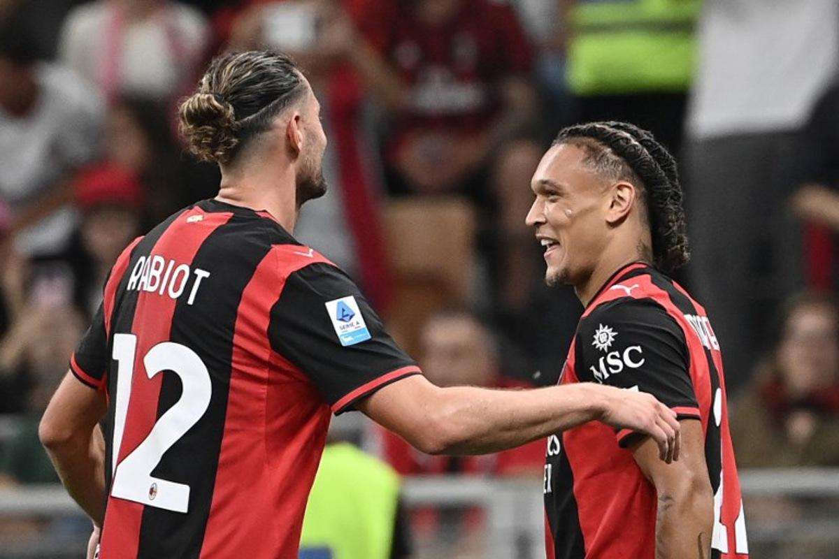 Milan's Belgian midfielder #22 Diego Moreira (R) celebrates with Milan's French midfielder #12 Adrien Rabiot (C) after scoring his team's third goal during the Italian Serie A football match between AC Milan and Lecce at the San Siro stadium in Milan, on September 20, 2026.  Isabella BONOTTO / AFP