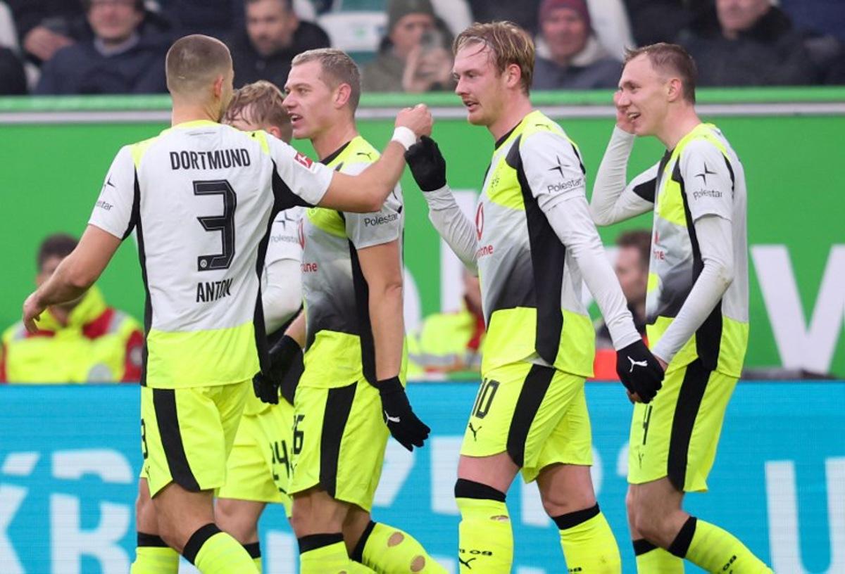 Dortmund's German midfielder #10 Julian Brandt (2R) celebrates with teammates scoring his team's first goal during the German first division Bundesliga football match between VfL Wolfsburg and Borussia Dortmund in Wolfsburg, on February 7, 2026.  Ronny HARTMANN / AFP