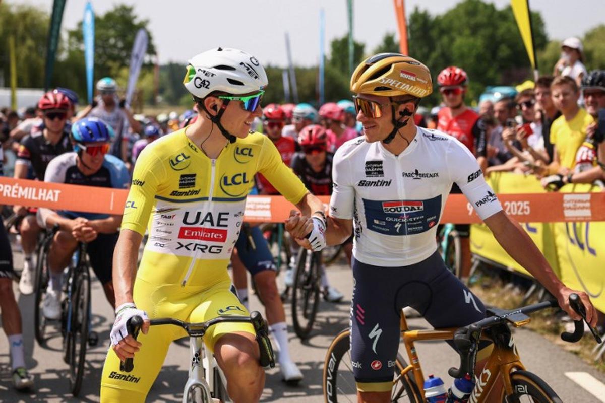 UAE Team Emirates XRG's Slovenian rider Tadej Pogačar (L) wearing the overall leader's yellow jersey shakes hands with Soudal Quick-Step's Belgian rider Remco Evenepoel wearing the best young rider's white jersey prior to the start of the 2nd stage of the 77th edition of the Criterium du Dauphine cycling race, 204,6 km between Prémilhat and Issoire, on June 9, 2025.  Anne-Christine POUJOULAT / AFP