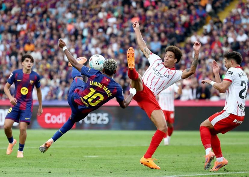 Barcelona's Spanish forward #10 Lamine Yamal fights for the ball with Girona's Belgian defender #20 Axel Witsel during the Spanish league football match between FC Barcelona and Girona FC at Estadi Olimpic Lluis Companys in Barcelona on October 18, 2025.  Josep LAGO / AFP