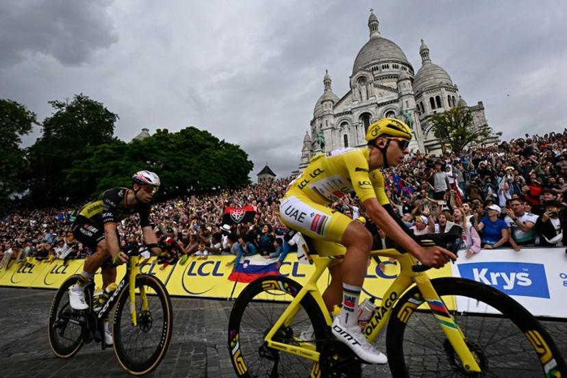 UAE Team Emirates - XRG team's Slovenian rider Tadej Pogacar wearing the overall leader's yellow jersey and Team Visma - Lease a bike team's Belgian rider Wout van Aert cycle past the Sacre-Coeur Basilica on the Butte de Montmartre during the 21st and final stage of the 112th edition of the Tour de France cycling race, 132.3 km between Mantes-la-Ville and Paris' Champs-Elysees Avenue, on July 27, 2025.  Loic VENANCE / AFP