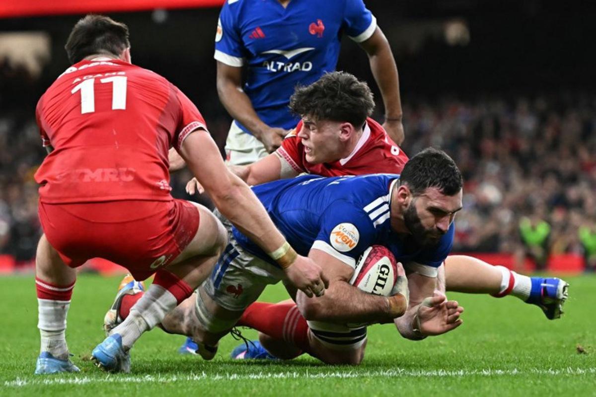 France's lock Charles Ollivon (R) dives for the line to score another try during the Six Nations international rugby union match between Wales and France at the Principality Stadium in Cardiff, south Wales, on February 15, 2026.  Paul ELLIS / AFP