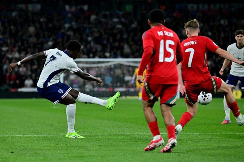 England's midfielder Bukayo Saka scores the team's third goal during the friendly football match between England and Wales at Wembley Stadium in London on October 9, 2025.   Ben STANSALL / AFP