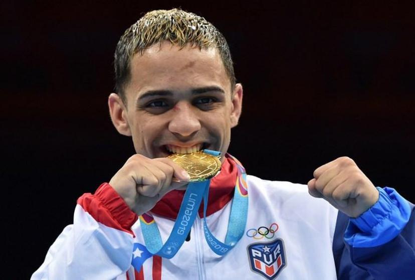 Puerto Rico's Oscar Collazo celebrates on the podium with his gold medal after defeating Colombia's Yuberjen Martinez in the Men's Light Fly (46-49kg) Final Bout of the Boxing competition Lima 2019 Pan-American Games at the Miguel Grau Coliseum in Callao on August 2, 2019.  Cris BOURONCLE / AFP