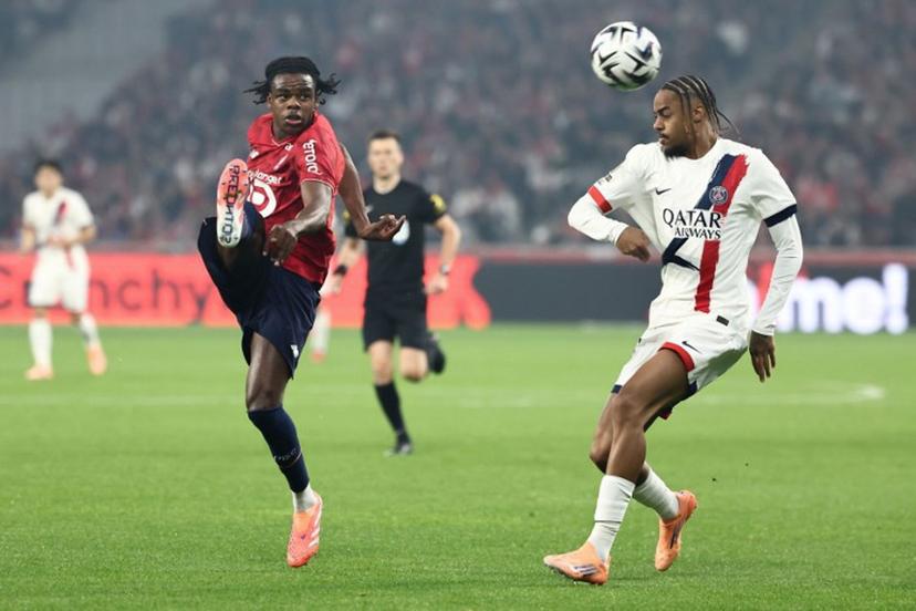 Lille's Belgian defender #03 Nathan Ngoy (CL) and Paris Saint-Germain's French forward #29 Bradley Barcola (CR) fight for the ball during the French L1 football match between Lille LOSC and Paris Saint-Germain (PSG) at the Stade Pierre-Mauroy in Villeneuve-d'Ascq, northern France, on October 5, 2025.  Sameer AL-DOUMY / AFP