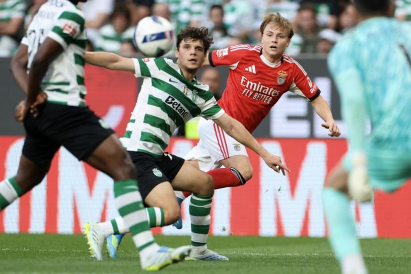 SL Benfica's Norwegian forward #21 Andreas Schjelderup  (R) wathces the ball challenged by Sporting Lisbon's Portuguese defender #72 Eduardo Quaresma during the Portuguese League football match between Sporting CP and SL Benfica at Jose Alvalade stadium in Lisbon, on April 19, 2026.  PATRICIA DE MELO MOREIRA / AFP