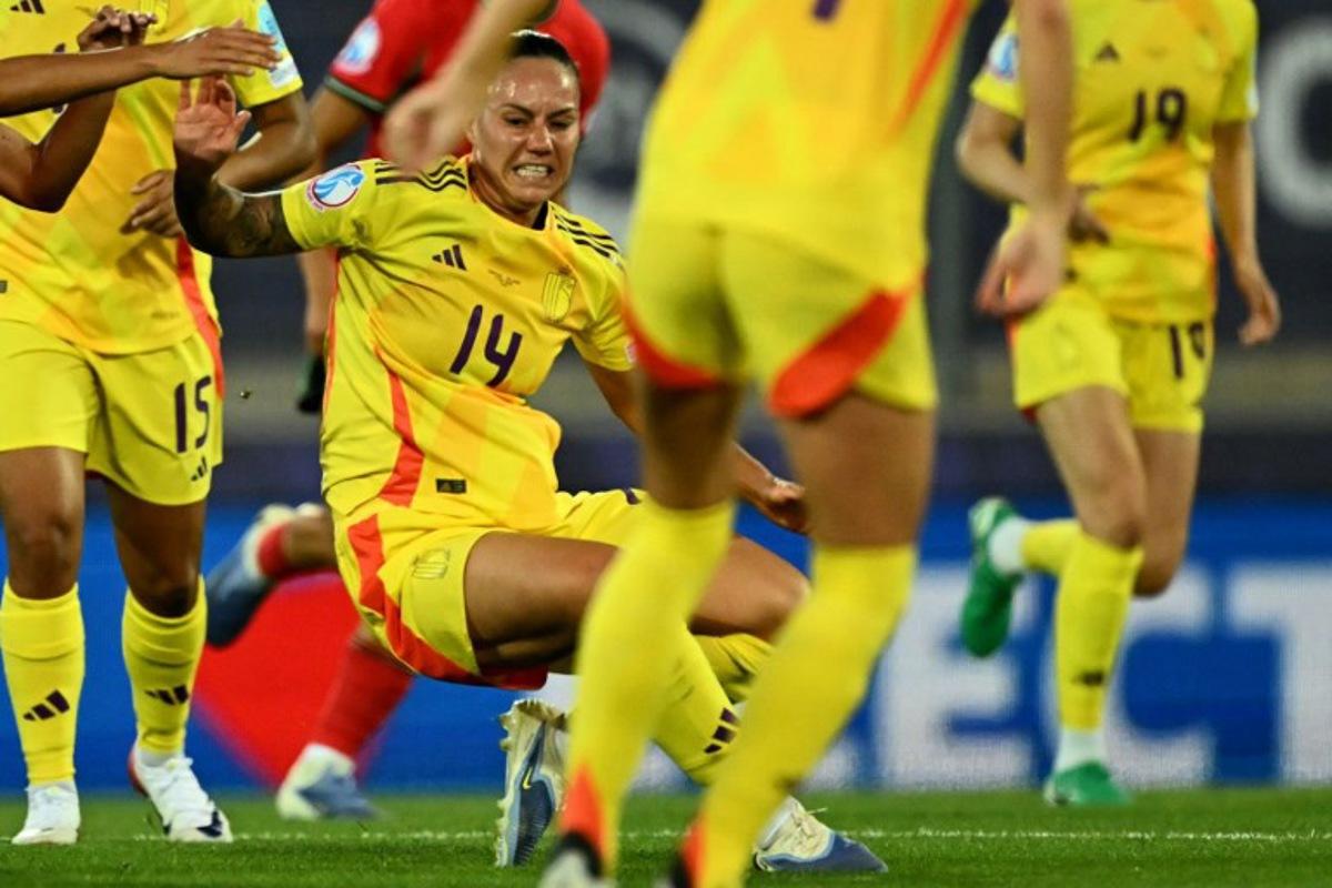 Belgium's forward #14 Jassina Blom (C) grimaces as she falls to the pitch and is later stretchered off, during the UEFA Women's Euro 2025 Group B football match between Portugal and Belgium at the Stade de Tourbillon in Sion, on July 11, 2025.  Fabrice COFFRINI / AFP