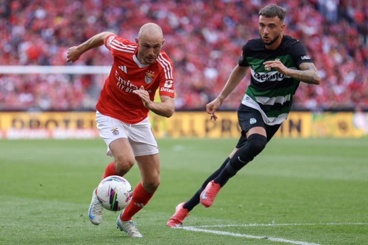 Benfica's Norwegian midfielder #08 Fredrik Aursnes (L) runs with the ball challenged by Sporting Lisbon's Belgian defender #06 Zeno Debast during the Portuguese League football match between SL Benfica and Sporting CP at Estadio da Luz in Lisbon, on May 10, 2025.  FILIPE AMORIM / AFP