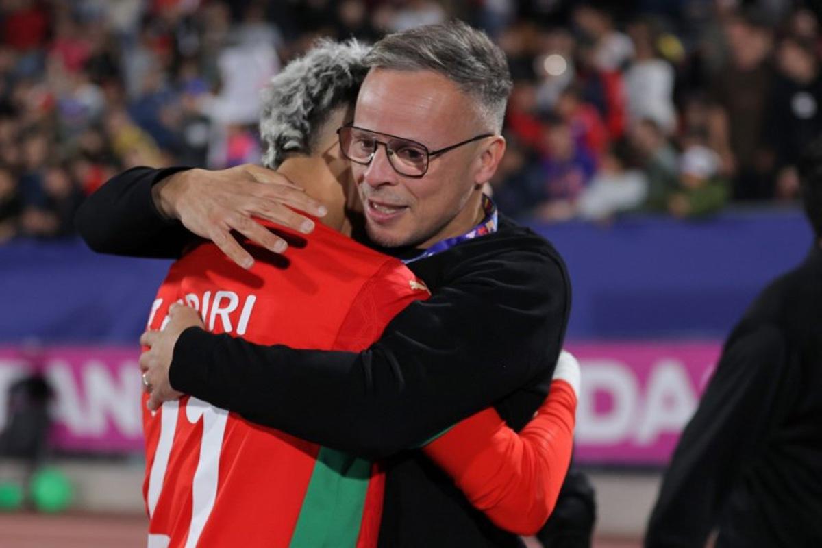 Morocco's head coach Mohamed Ouahbi and forward #21 Yassir Zabiri celebrate after winning the 2025 FIFA U-20 World Cup final football match between Argentina and Morocco at the National Stadium in Santiago on October 19, 2025.  Javier TORRES / AFP