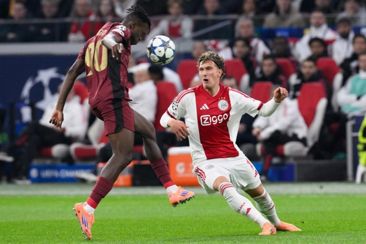 Galatasaray's Ivorian defender #90 Wilfried Singo (L) fights for the ball with Ajax's Belgian forward #11 Mika Godts (R) during the UEFA Champions League, league phase day 4, football match between Ajax and Galatasaray at the Johan Cruijff ArenA in Amsterdam on November 5, 2025.  JOHN THYS / AFP