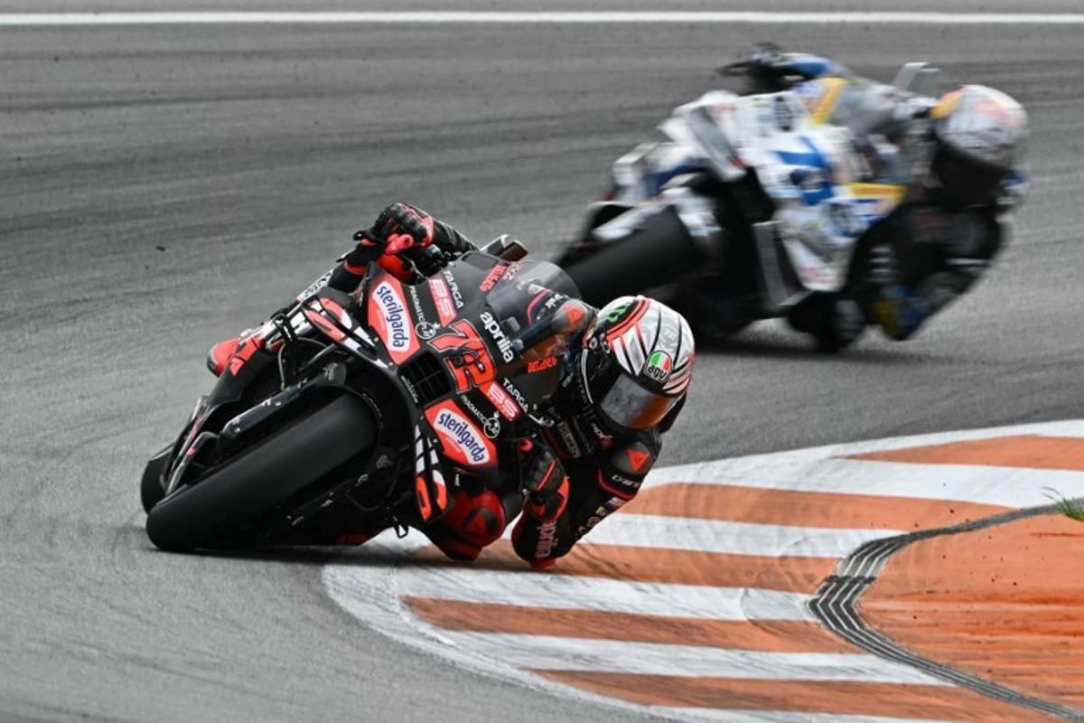 Aprilia Racing team's Italian MotoGP rider Marco Bezzecchi rides ahead of BK8 Gresini Racing MotoGP team's Spanish MotoGP rider Alex Marquez in the MotoGP race of the Valencia Grand Prix at the Ricardo Tormo racetrack in Cheste on November 16, 2025.  Javier SORIANO / AFP