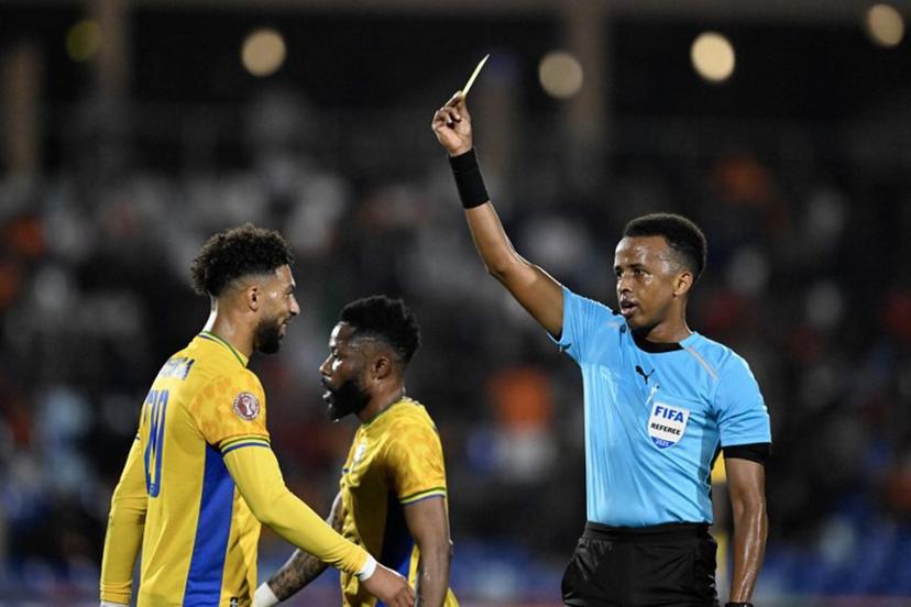 (FILES) Gabon's forward #20 Denis Bouanga is shown the yellow card by Somali referee Omar Abdulkadir Artan during the Africa Cup of Nations (CAN) Group F football match between Gabon and Ivory Coast at the Grand Stadium in Marrakech on December 31, 2025.  Award-winning Somali referee Omar Artan, set to be the first from his country to officiate at the World Cup, was denied entry to the United States, a sports ministry official told AFP on June 8, 2026.  "Denying him entry to the United States and preventing him from officiating scheduled matches harms not only him personally but also undermines football's commitment to fairness, merit, and the spirit of fair play," Ciise Aden Abshir, a senior advisor to Somalia's Ministry of Youth and Sports and a former national team captain, told AFP.  Khaled DESOUKI / AFP