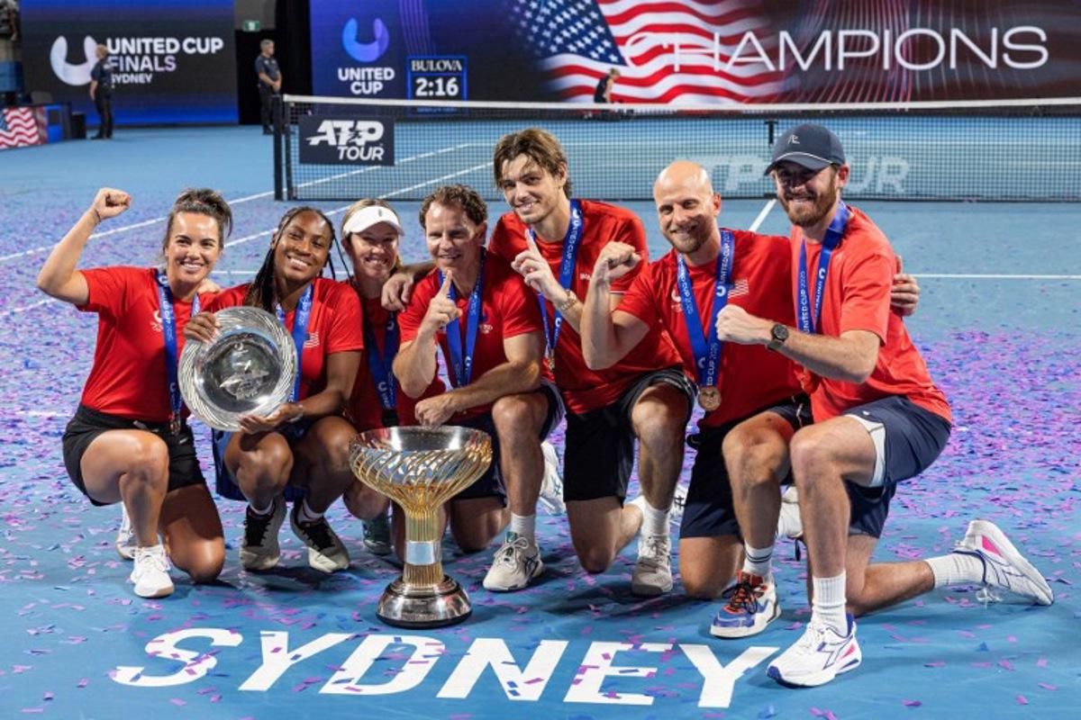 Players of Team USA celebrate with the trophy after beating team Poland in the finals of the United Cup tennis tournament on Ken Rosewall Arena in Sydney on January 5, 2025.  Steve CHRISTO / AFP