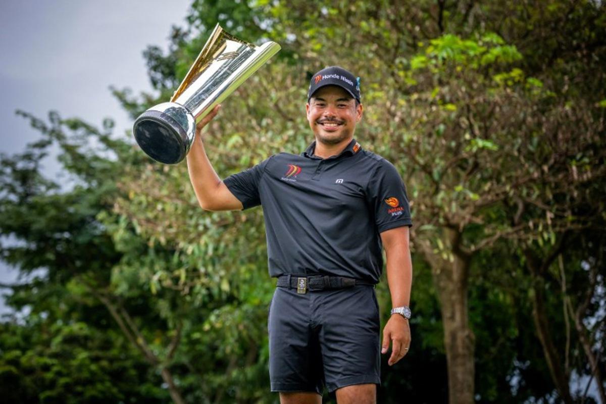 This handout photograph from the Asian Tour taken and received on October 26, 2025 shows Philippines' Miguel Tabuena posing with the trophy during the presentation ceremony, after winning the International Series Philippines golf tournament at Sta. Elena Golf Club in Santa Rosa, Laguna province.  Graham Uden / Asian Tour / AFP