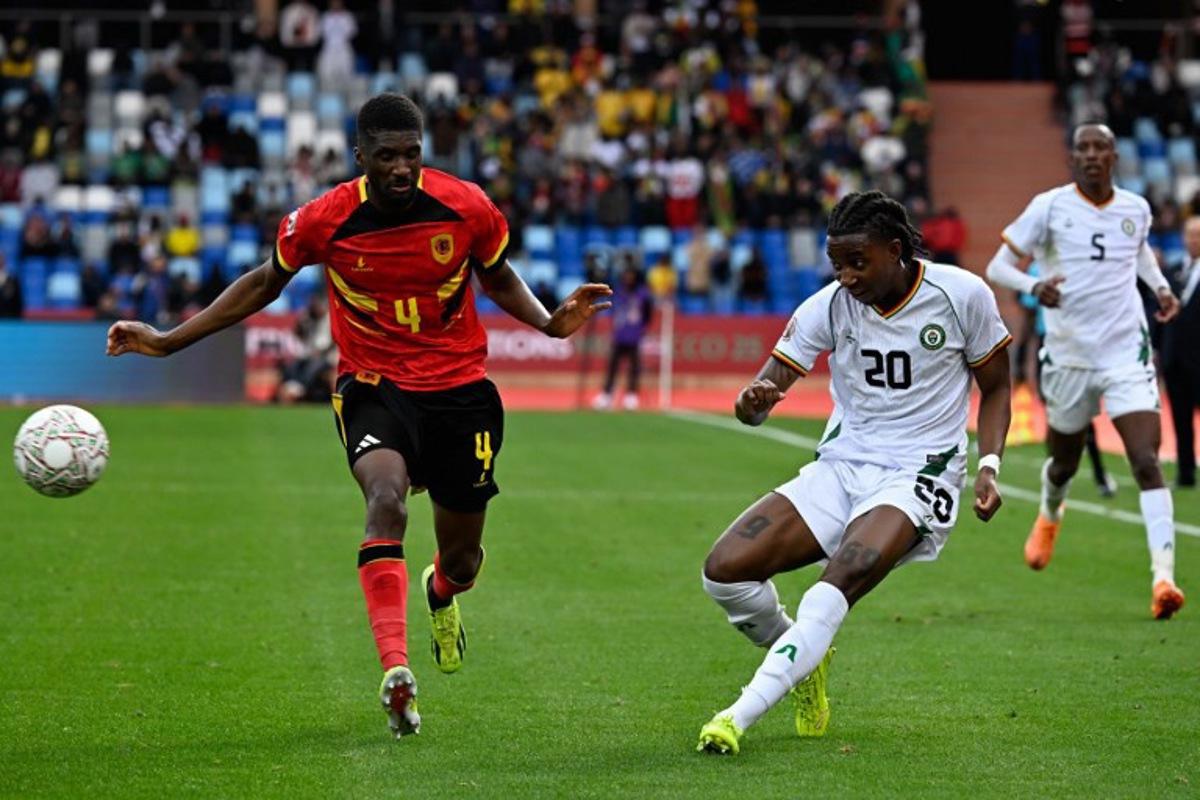 Zimbabwe's forward #20 Tawanda Chirewa crosses the ball past Angola's defender #04 Clinton Mata during the Africa Cup of Nations (CAN) Group B football match between Angola and Zimbabwe at Marrakesh Stadium in Marrakesh on December 26, 2025.   Khaled DESOUKI / AFP