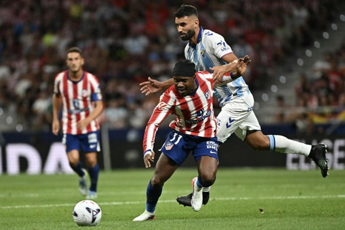 Atletico Madrid's Nigerian forward #11 Ademola Lookman vies with Malaga's Spanish defender #04 Einar Galilea (R) during the Spanish league football match between Club Atletico de Madrid and Malaga CF at the Metropolitano Stadium in Madrid on August 19, 2026.  Javier SORIANO / AFP