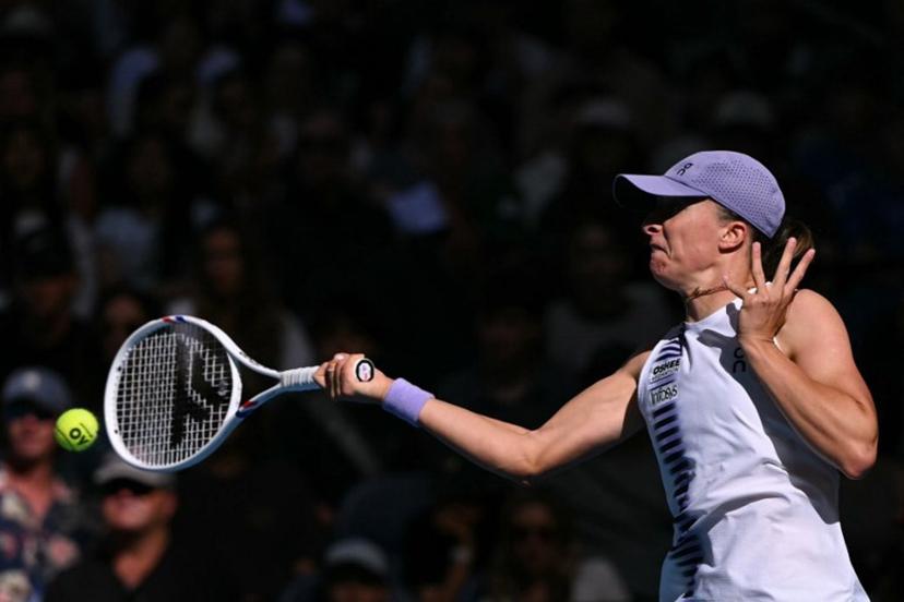 Poland's Iga Swiatek hits a return to Czech Republic's Marie Bouzkova during their women's singles match on day five of the Australian Open tennis tournament in Melbourne on January 22, 2026.  WILLIAM WEST / AFP