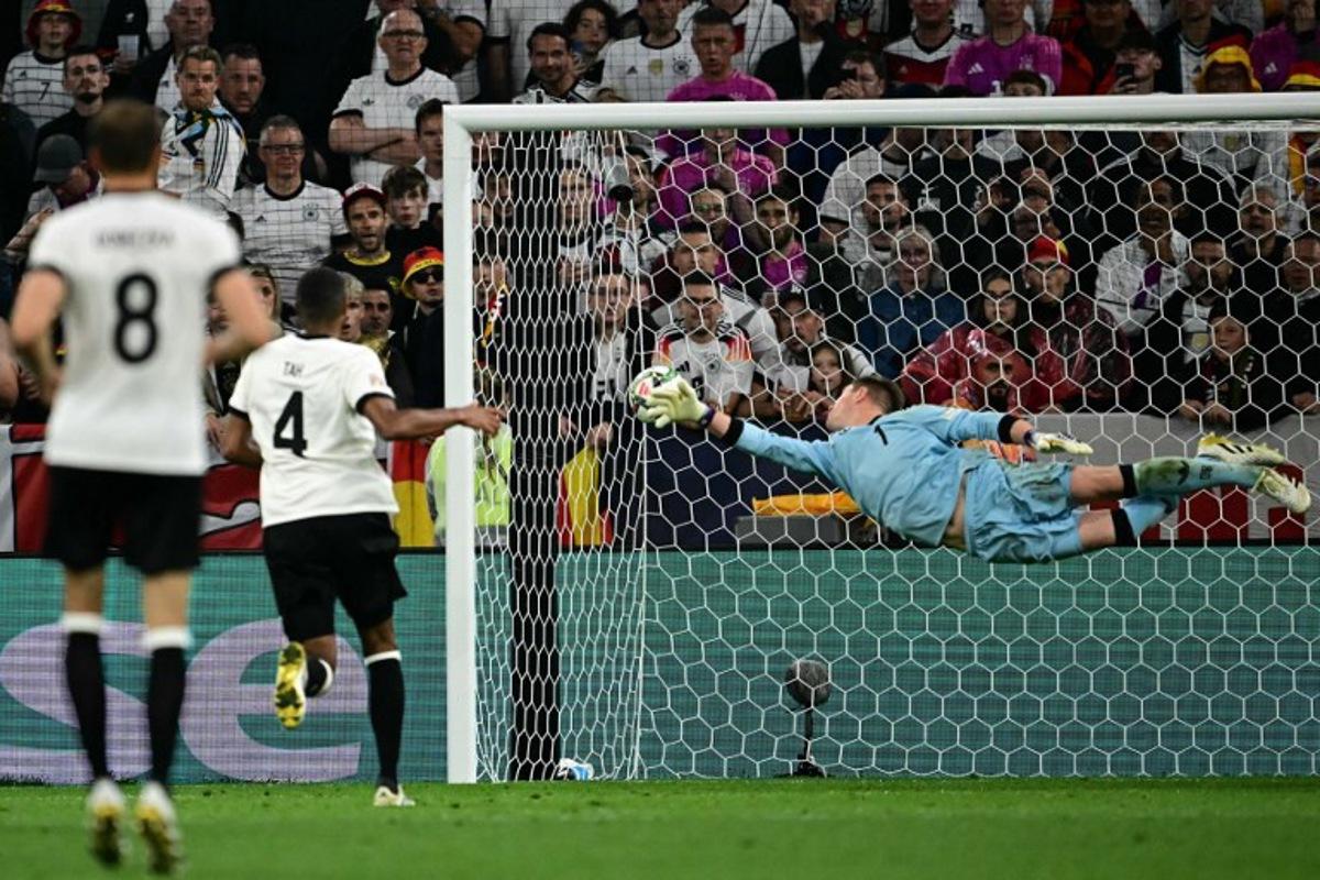 Germany's goalkeeper #01 Marc-Andre Ter Stegen dives but fails to save the 1-1 goal during the UEFA Nations League semi-final football match between Germany and Portugal in Munich, southern Germany on June 4, 2025.  Tobias SCHWARZ / AFP