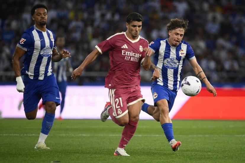 Deportivo La Coruna's Spanish midfielder #21 Mario Soriano Carreno (R) and Real Madrid's Moroccan forward #21 Brahim Diaz (C) vie for the ball during the Teresa Herrera Trophy friendly football match between RC Deportivo de la Coruna and Real Madrid CF at Municipal de Riazor Stadium in A Coruna on August 12, 2026.  Miguel RIOPA / AFP