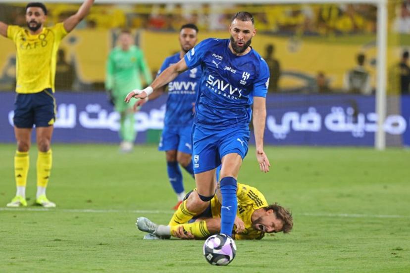Nassr's Spanish defender #26 Inigo Martinez (down) reacts as Al-Hilal French forward #90 Karim Benzema fights for the ball with during the Saudi Pro League football match between Al-Nassr and Al-Hilal at King Fahd Sports City Stadium in Riyadh on May 12, 2026.  Fayez NURELDINE / AFP
