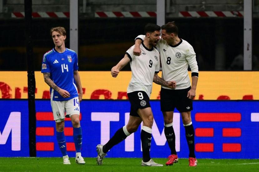 Germany's forward #09 Tim Kleindienst celebrates after scoring his team's first goal with Germany's midfielder #08 Leon Goretzka during the Nations League quarter final first leg football match between Italy and Germany at the San Siro Stadium in Milan, on March 20, 2025.  Marco BERTORELLO / AFP