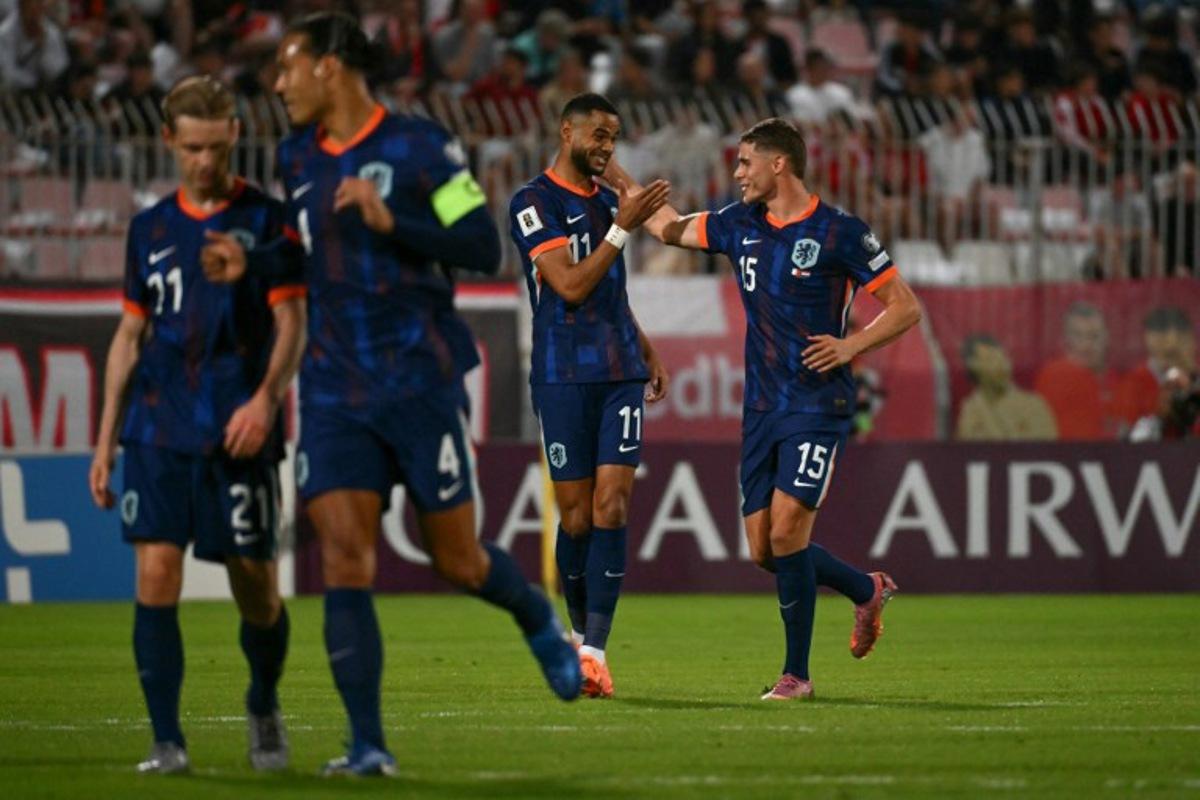Netherlands' forward #11 Cody Gakpo (C) celebrates with Netherlands' defender #15 Micky van de Ven (R) after succesfully converting a penalty to score the Netherlands' first goal during the FIFA World Cup 2026 Group G qualification football between Malta and Netherlands at the National Stadium in Ta' Qali, on October 9, 2025.  Alberto PIZZOLI / AFP