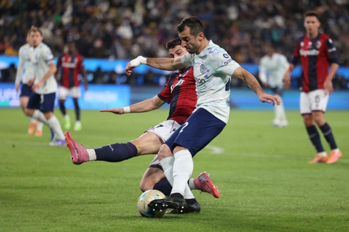 Inter Milan's Armenian forward #22 Henrikh Mkhitaryan (R) is tackled by Bologna's Italian forward #07 Riccardo Orsolini (L) during the Italian Super Cup semi-final match between Inter Milan and Bologna FC 1909 at King Al-Awwal Park Stadium, in Riyadh on December 19, 2025.    Fayez Nureldine / AFP