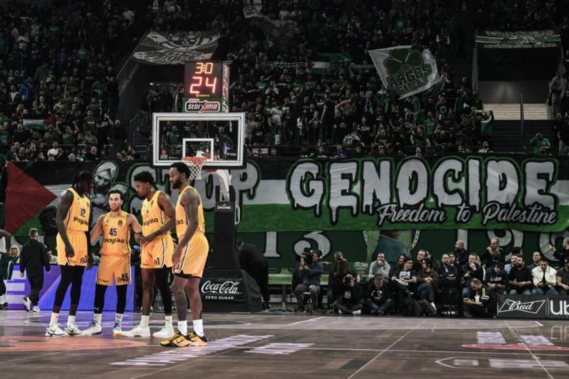 Fans of Panathinaikos hold a banner that reads "Stop Genocide. Freedom to Palestin" during the Euroleague basketball match between Panathinaikos Athens and Maccabi Tel Aviv at the OAKA stadium in Athens on November 12, 2024.  Angelos TZORTZINIS / AFP