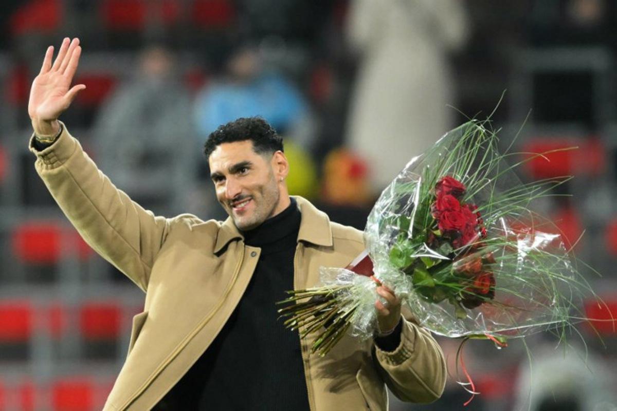 Former Belgian football player Marouane Fellaini holds a bouquet of flowers during a ceremony ahead of the FIFA World Cup 2026 Group J European qualification football match between Belgium and Liechtenstein at the Maurice-Dufrasne stadium, in Liege, on November 18, 2025.   NICOLAS TUCAT / AFP