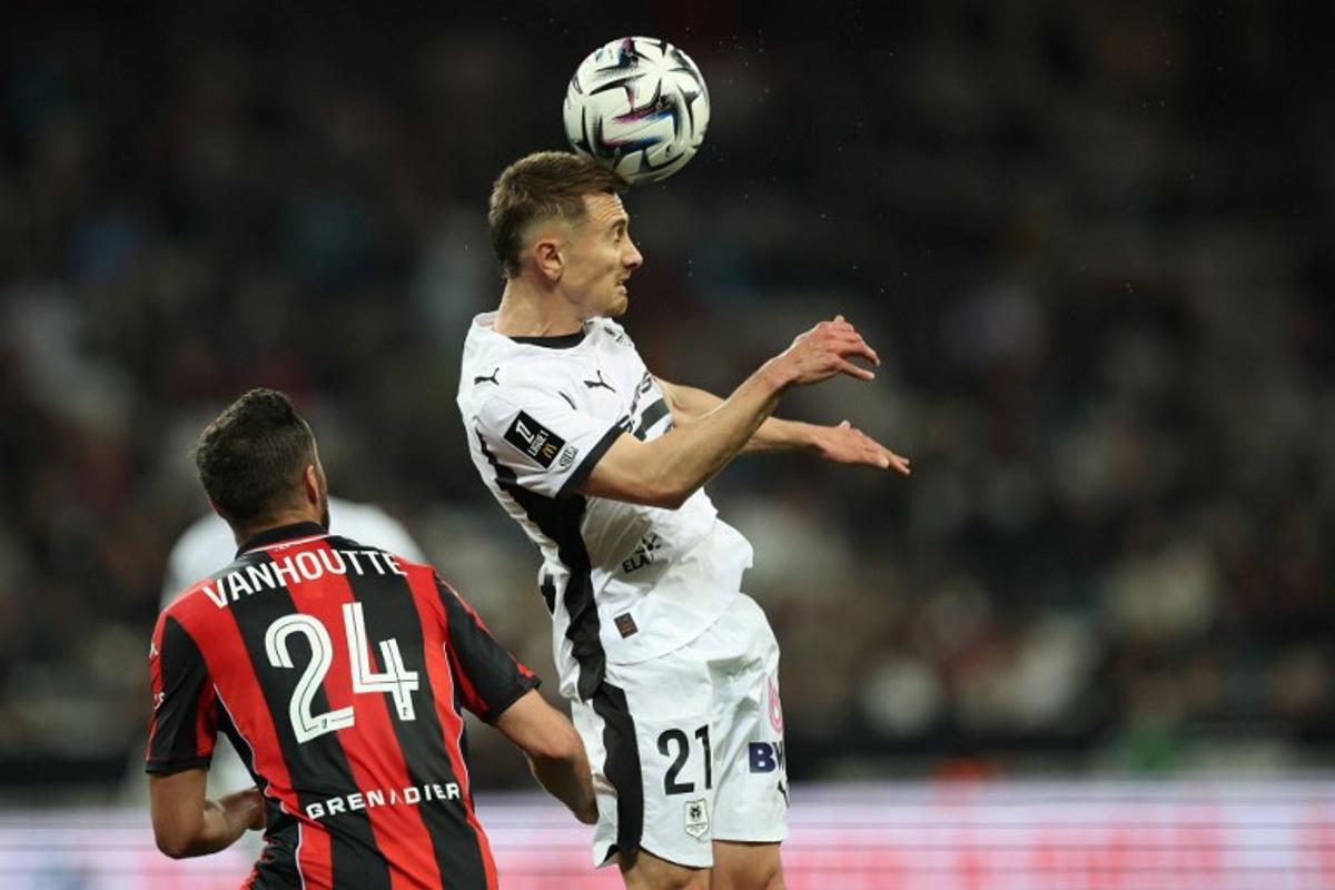 Rennes' French midfielder #21 Valentin Rongier (C) heads the ball in front of Nice's Belgian midfielder #24 Charles Vanhoutte (L) during the French L1 football match between OGC Nice and Stade Rennais FC at the Allianz Riviera Stadium in Nice, south-eastern France, on March 8, 2026.  Valery HACHE / AFP