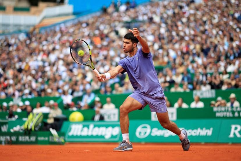 Spain's Carlos Alcaraz plays a backhand return to Spain's Alejandro Davidovich Fokina during the Monte Carlo ATP Masters Series Tournament semi-final tennis match at the Monte Carlo Country Club in Roquebrune-Cap-Martin on April 12, 2025.  Valery HACHE / AFP