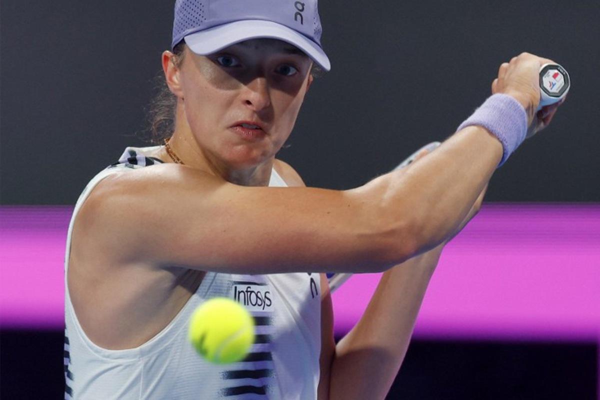 Poland's Iga Swiatek returns a shot during her women's singles quarter-final match against Greece's Maria Sakkari at the Qatar Open tennis tournament in Doha on February 12, 2026.  Karim JAAFAR / AFP