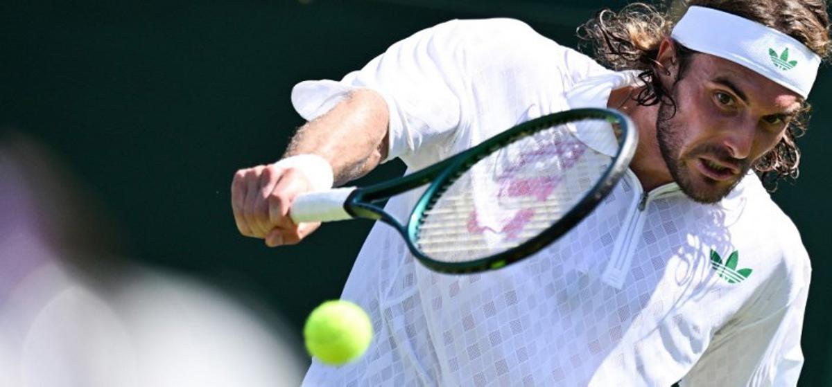 Greece's Stefanos Tsitsipas plays a backhand return to France's Valentin Royer during their men's singles first round tennis match on the first day of the 2025 Wimbledon Championships at The All England Lawn Tennis and Croquet Club in Wimbledon, southwest London, on June 30, 2025.  Kirill KUDRYAVTSEV / AFP
