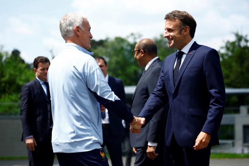 French President Emmanuel Macron (R) shakes hands with French headcoach Didier Deschamps as he arrives for a lunch at the team's training camp, as part of the team's preparation for the UEFA Euro 2024 European football championships in Clairefontaine-en-Yvelines on June 3, 2024.  Sarah Meyssonnier / POOL / AFP