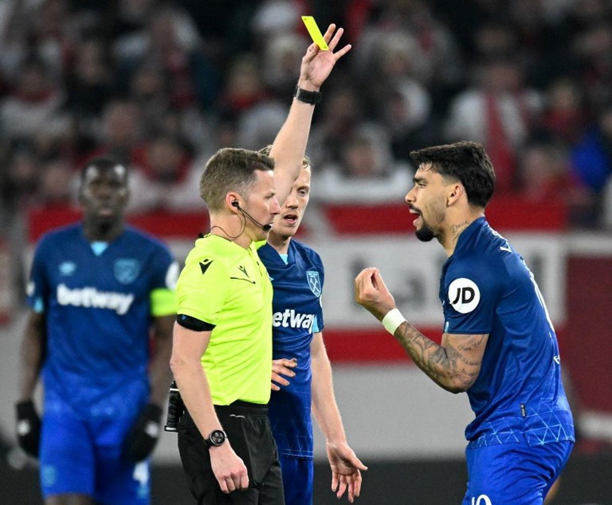 West Ham United's Brazilian midfielder #10 Lucas Paqueta (R) is shown a yellow card by Spanish referee Alejandro Hernandez during the UEFA Europa League round of 16 first leg football match between SC Freiburg and West Ham United FC in Freiburg, southwestern Germany on March 7, 2024.   THOMAS KIENZLE / AFP