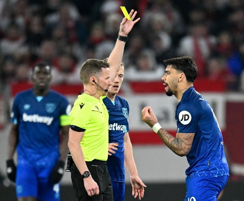 West Ham United's Brazilian midfielder #10 Lucas Paqueta (R) is shown a yellow card by Spanish referee Alejandro Hernandez during the UEFA Europa League round of 16 first leg football match between SC Freiburg and West Ham United FC in Freiburg, southwestern Germany on March 7, 2024.   THOMAS KIENZLE / AFP