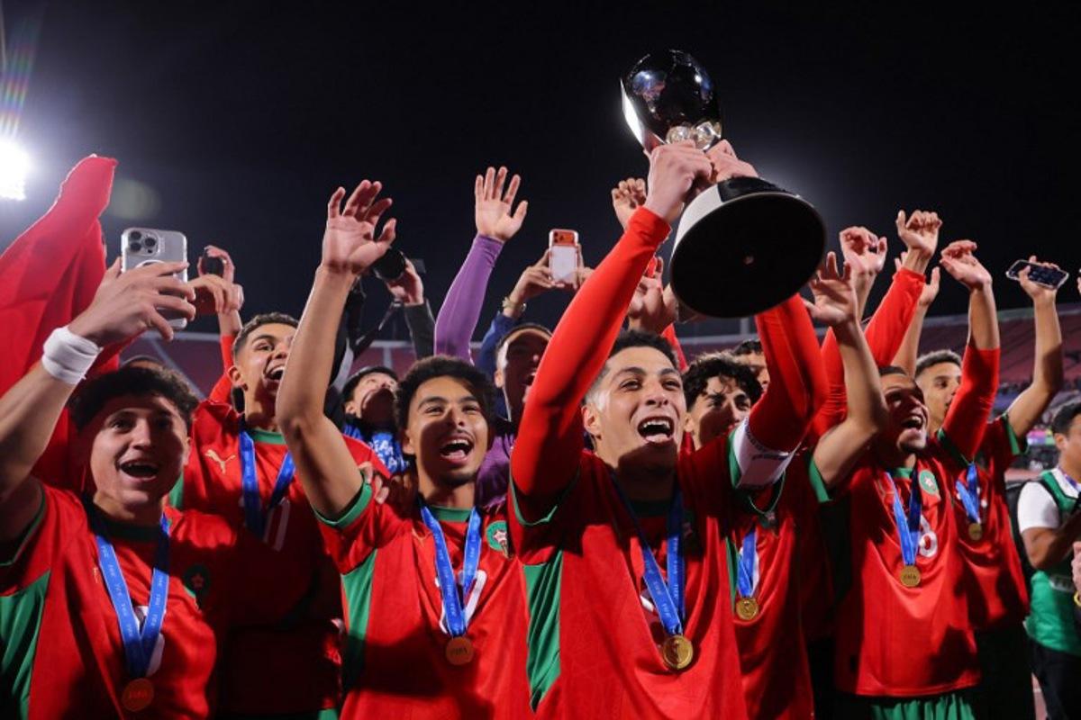 Morocco's midfielder #08 Houssam Essadak holds the trophy while celebrating with his teammates after winning the 2025 FIFA U-20 World Cup final football match between Argentina and Morocco at the National Stadium in Santiago on October 19, 2025.  Javier TORRES / AFP